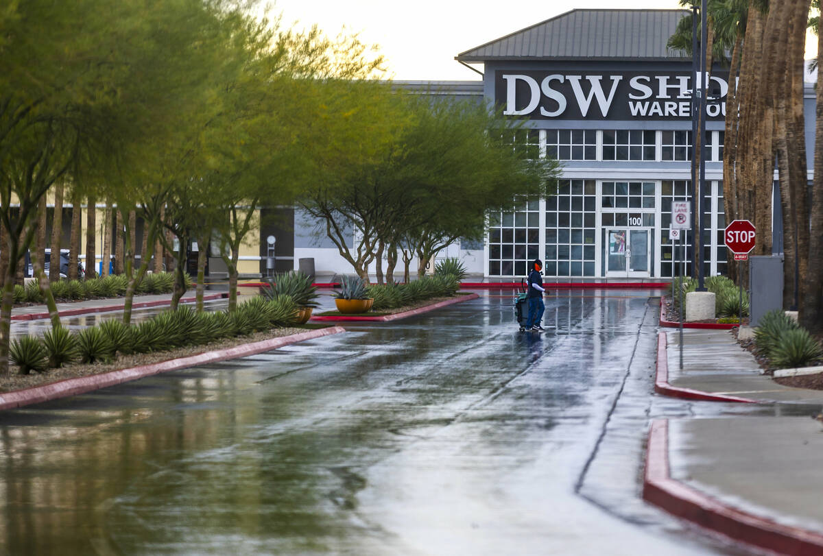 A maintenance worker makes their way across a parking lot near a DSW Shoe Warehouse off of Nort ...