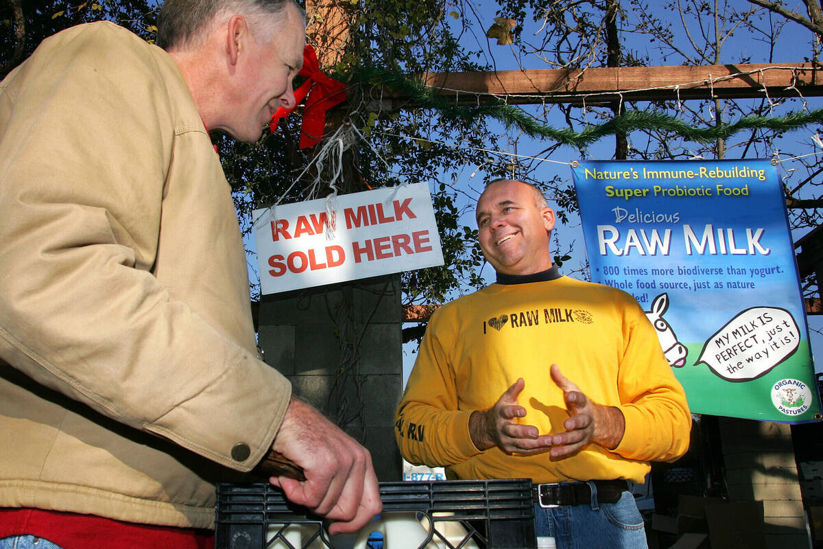 Veterinarian Patrick Smith, left, discusses raw milk with dairyman and producer Mark McAfee at ...