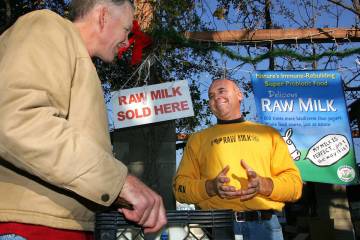 Veterinarian Patrick Smith, left, discusses raw milk with dairyman and producer Mark McAfee at ...