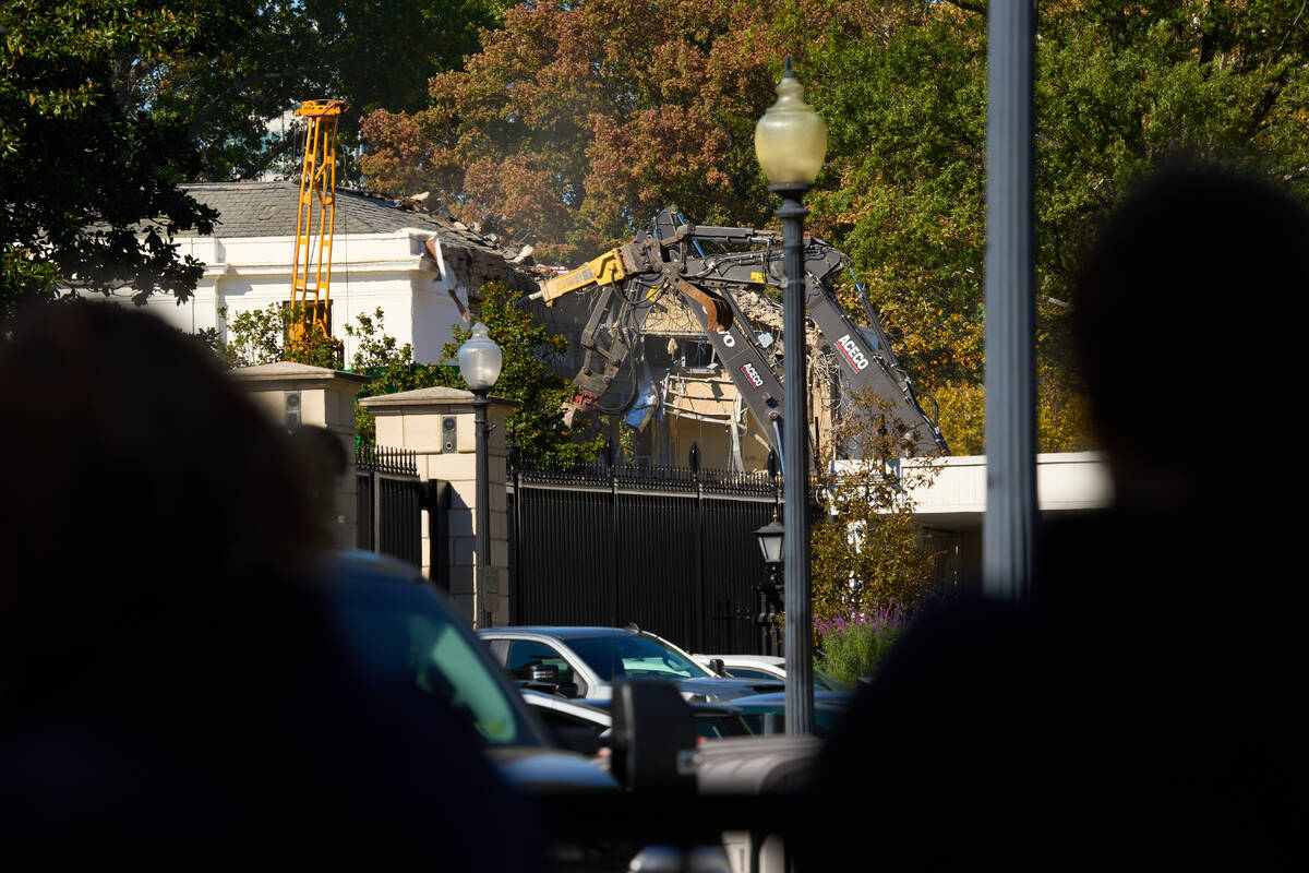 People watch as work continues on the demolition of a part of the East Wing of the White House, ...
