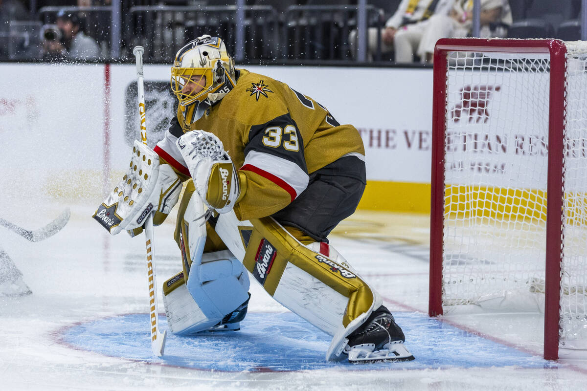 Golden Knights goaltender Adin Hill (33) is showered in ice as he defends the net against the U ...