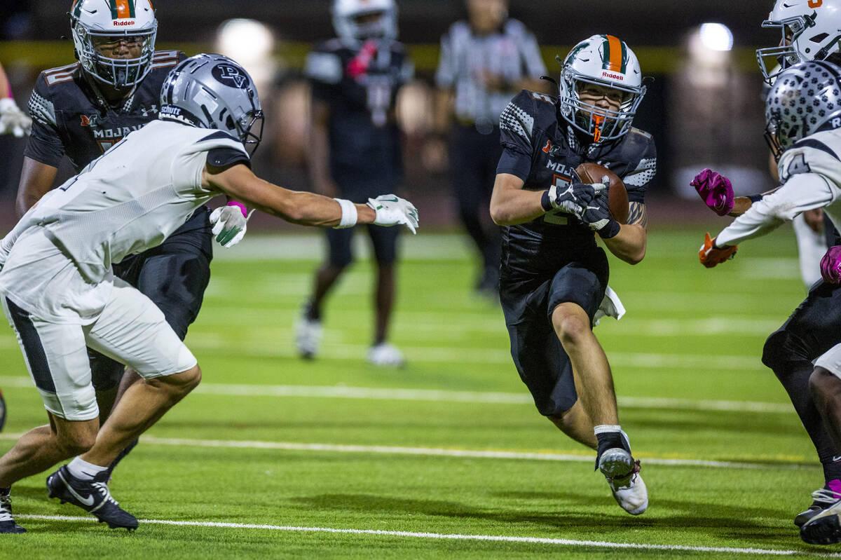 Mojave's Francisco Reinares (2) looks to split the Palo Verde defense on another long run ...