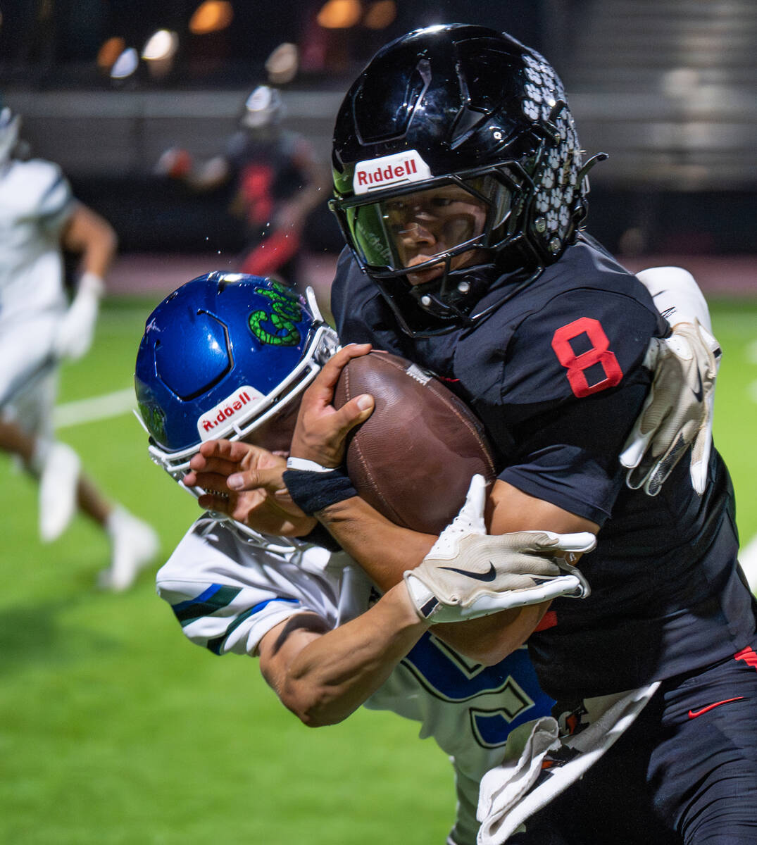 Las Vegas quarterback Tanner Vibabul (8) is taken down by Green Valley’s Sam Byington (5) dur ...