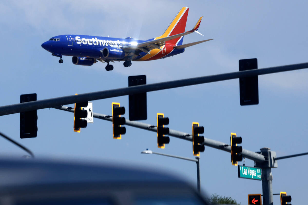 A Southwest Airlines plane flies over traffic on Las Vegas Boulevard as it approaches Harry Rei ...