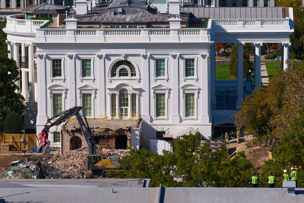 Construction workers, bottom right, atop the U.S. Treasury, watch as work continues on a largel ...
