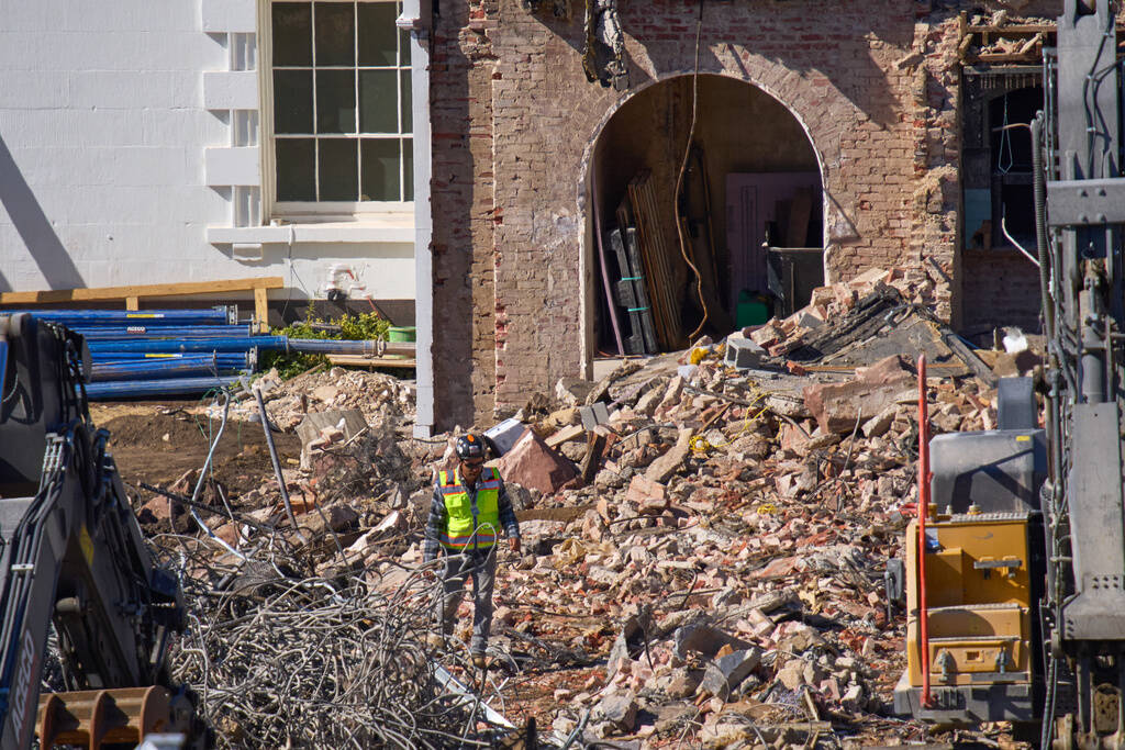 A worker walks through debris at a largely demolished part of the East Wing of the White House, ...