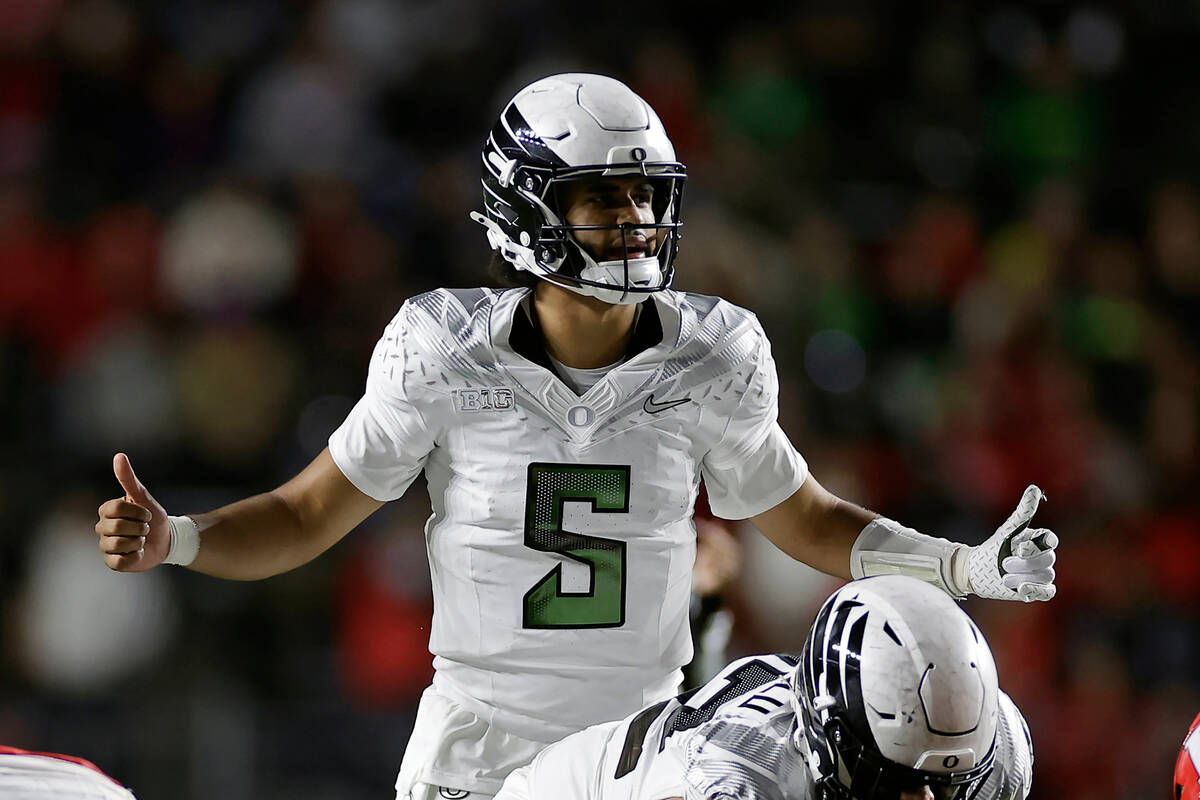Oregon quarterback Dante Moore (5) gestures at the line of scrimmage during the first half of a ...