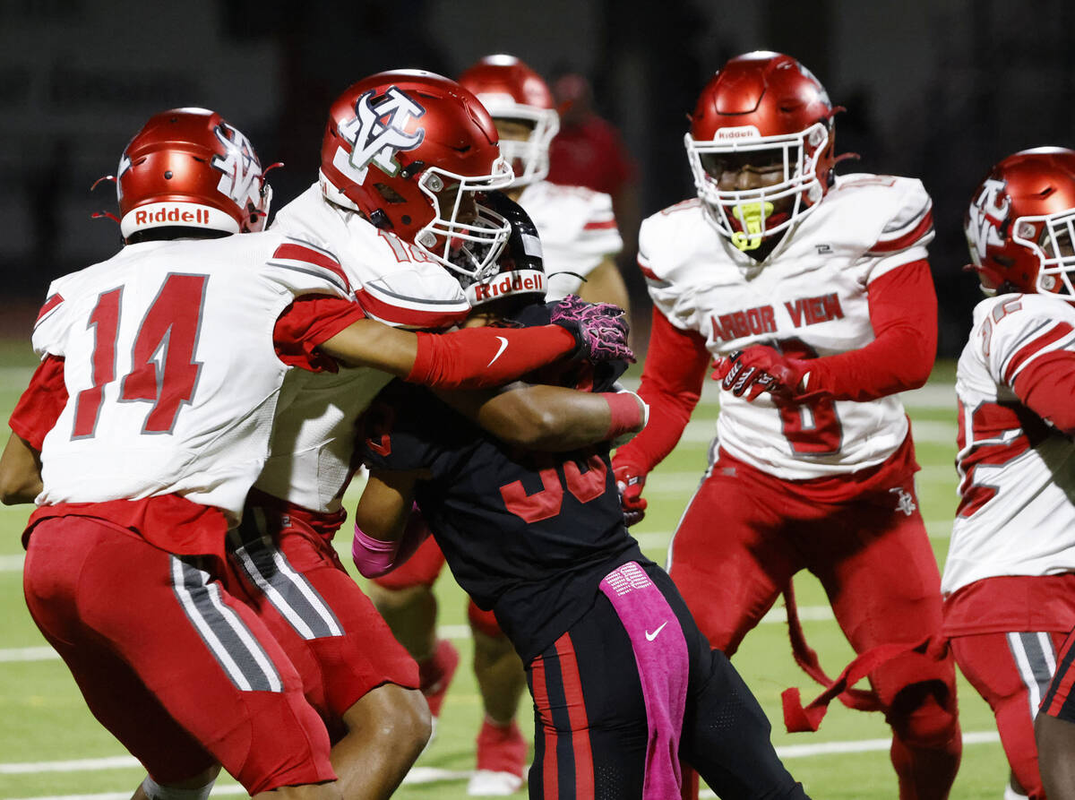 Las Vegas High's Edgar Soto (33) is taken down by Arbor View High's defense during a ...