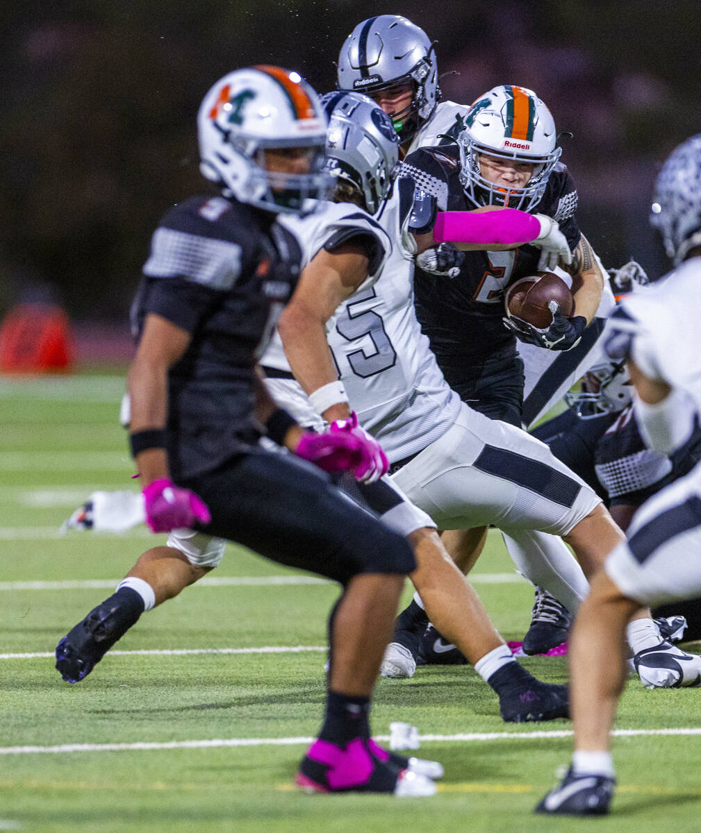 Mojave's Francisco Reinares (2) is grabbed by Palo Verde's Kyle Johnson (85) on a run ...