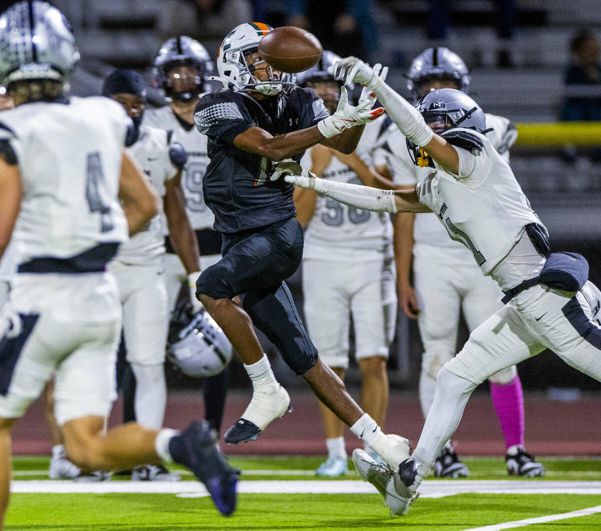 Mojave's Demier Zamora (14) fights for a pass as Palo Verde's Landon Powell (11) gets ...