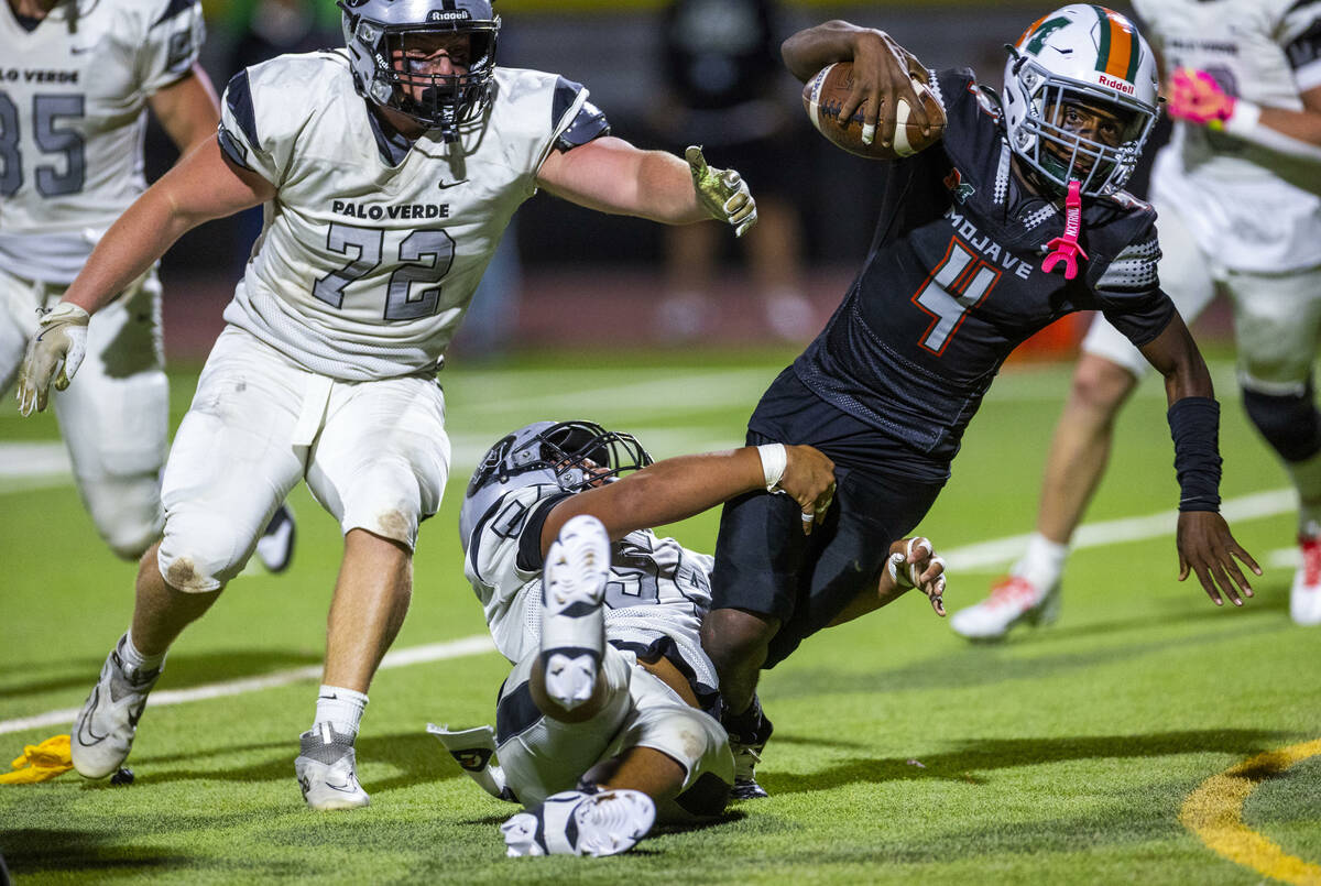 Palo Verde's Moziah Kitiona (54) catches Mojave quarterback RaJahn Butler (4) after anothe ...