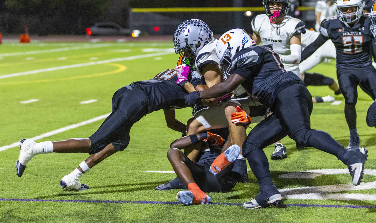 Palo Verde's Beau Gardineer (4) is gang tackled by Mojave defenders during the second half ...