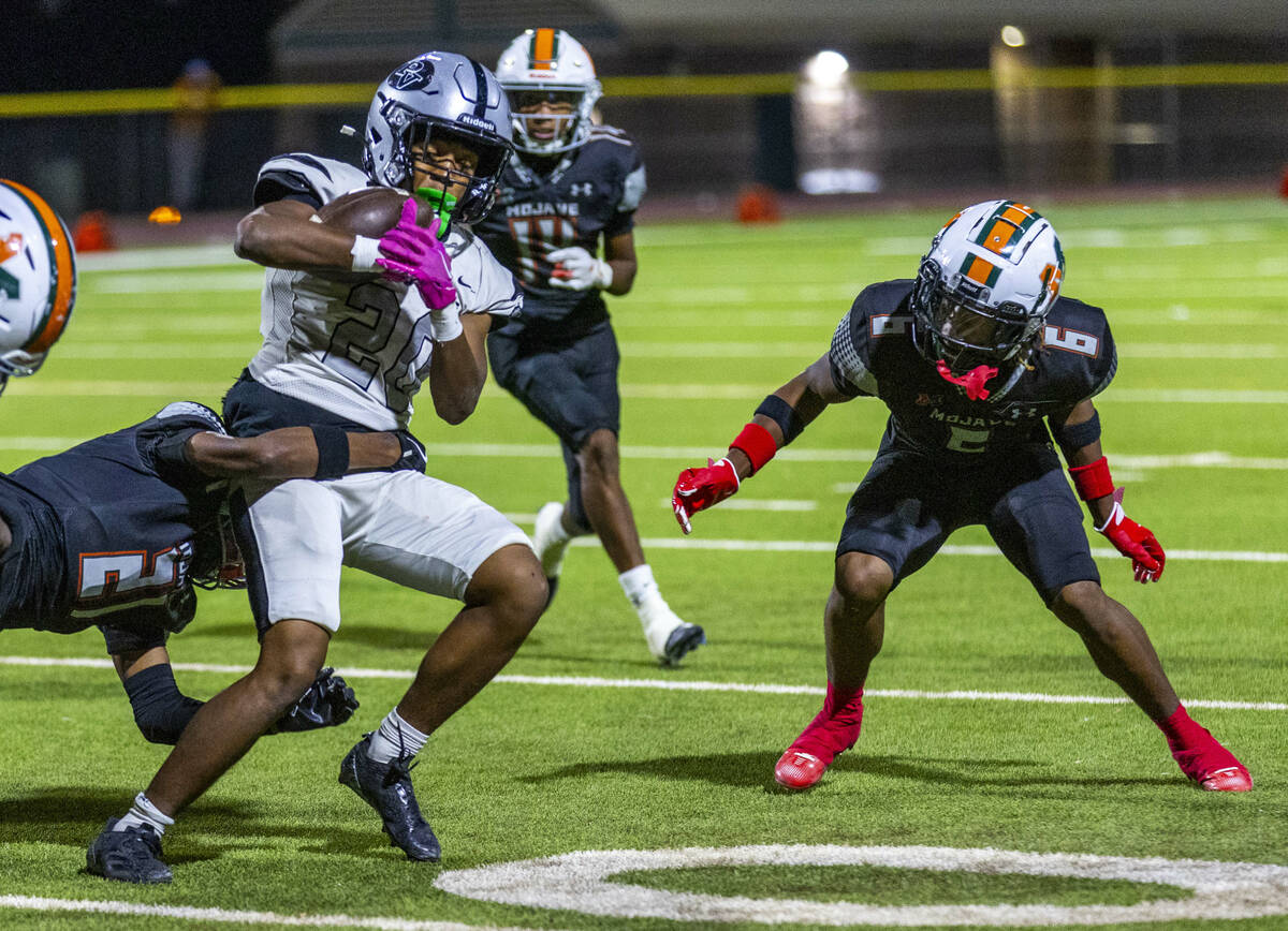 Palo Verde's Rio Pascal (20) holds onto the ball while being brought down by Mojave's ...