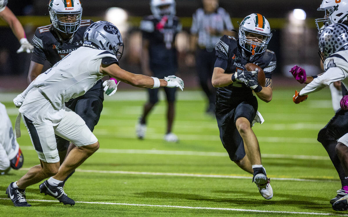 Mojave's Francisco Reinares (2) looks to split the Palo Verde defense on another long run ...