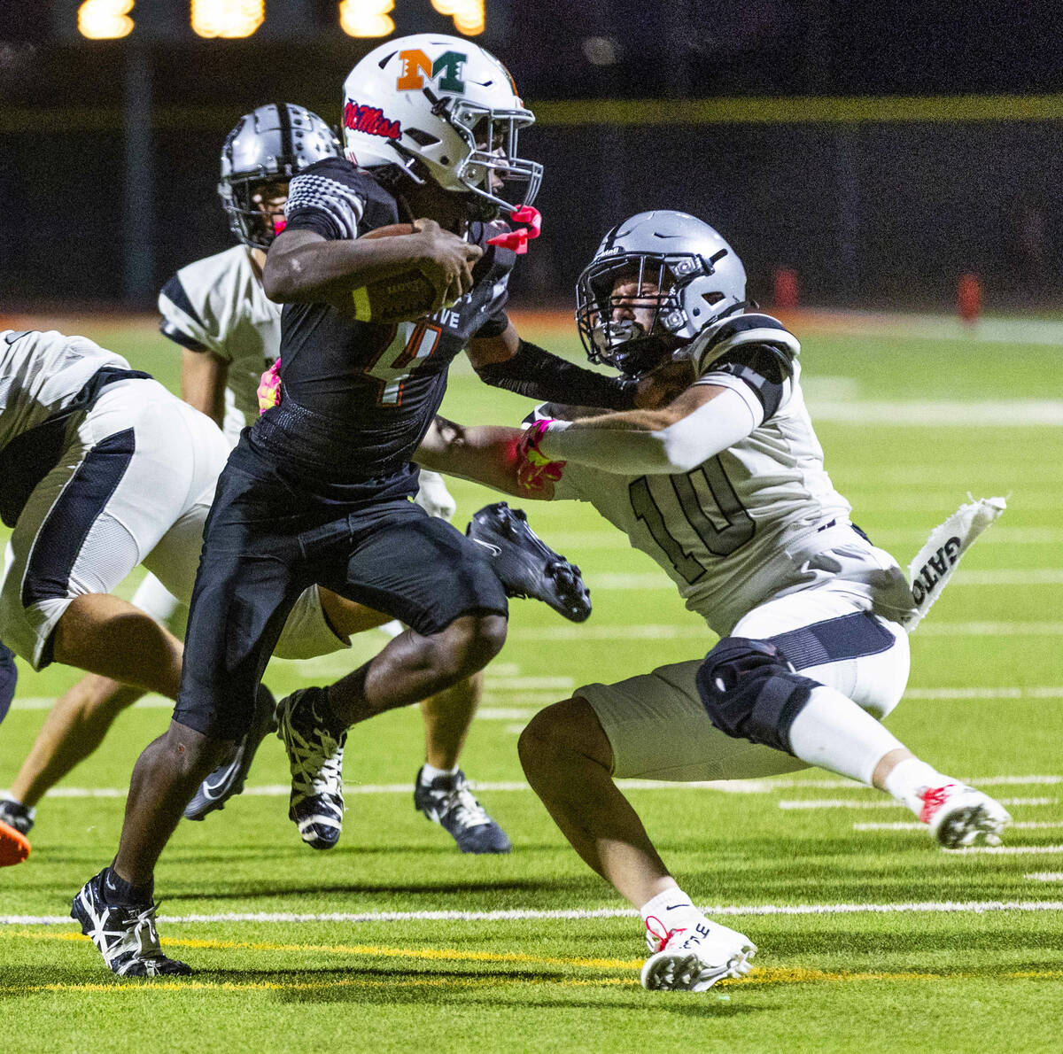 Mojave quarterback RaJahn Butler (4) evades a tackle attempt by Palo Verde's Owen Anderson ...