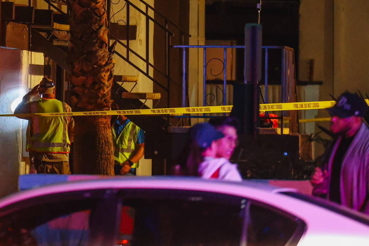 Investigators sift through remains from a fire after a woman was found dead at Casa Vegas Condo ...