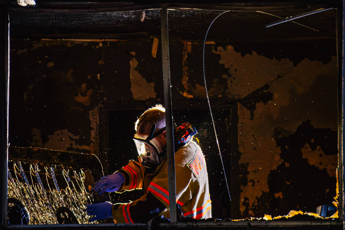 Investigators sift through remains from a fire after a woman was found dead at the Casa Vegas c ...