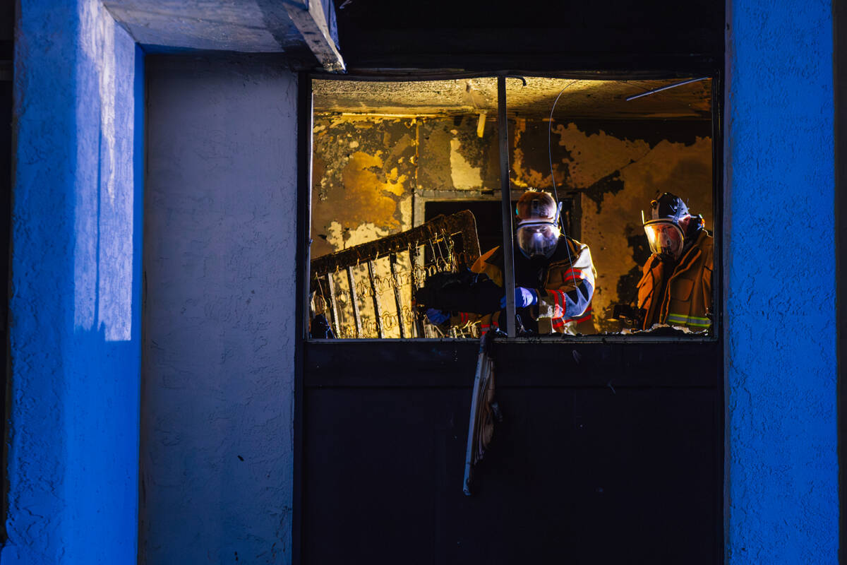 Investigators sift through remains from a fire after a woman was found dead at the Casa Vegas c ...