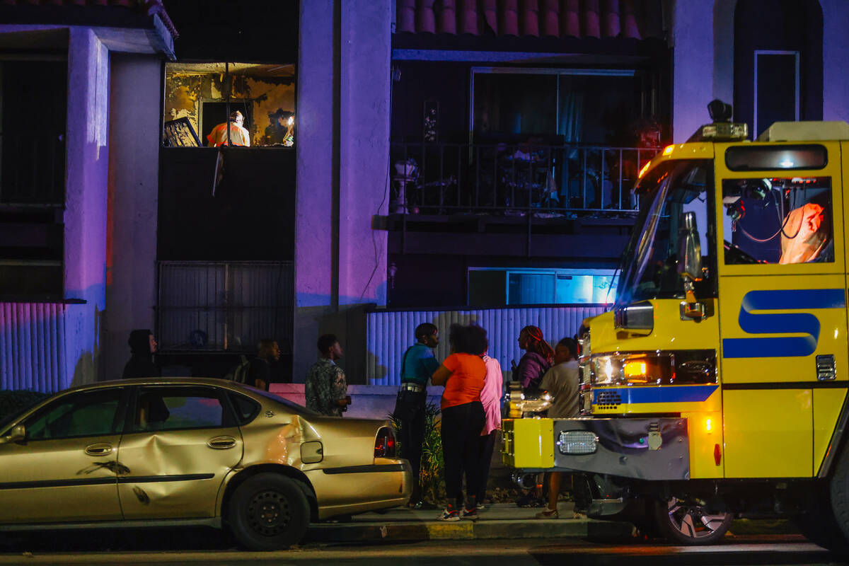 Investigators sift through remains from a fire after a woman was found dead at Casa Vegas Condo ...