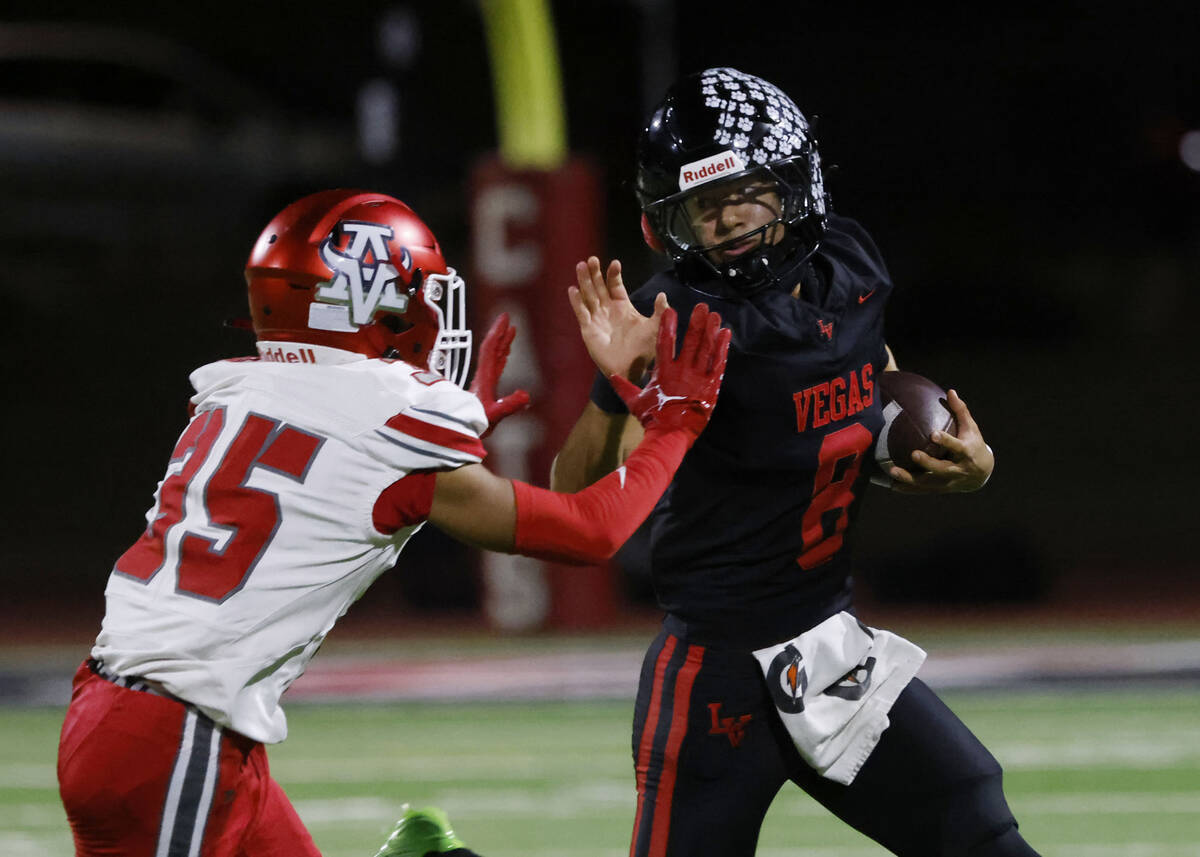 Las Vegas High's quarterback Tanner Vibabul (8) avoids a tackle from Arbo View's defe ...