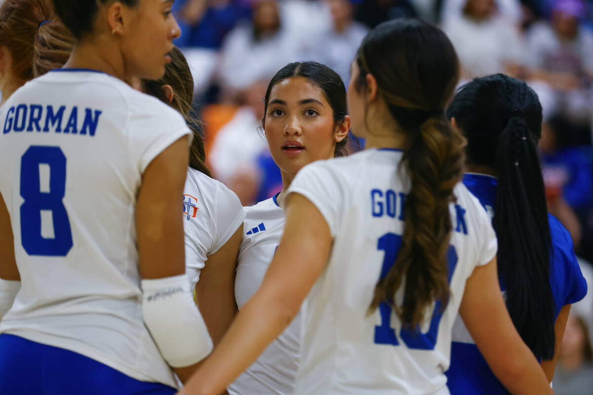 Bishop Gorman setter Trinity Thompson (9) huddles with her team during a volleyball game agains ...