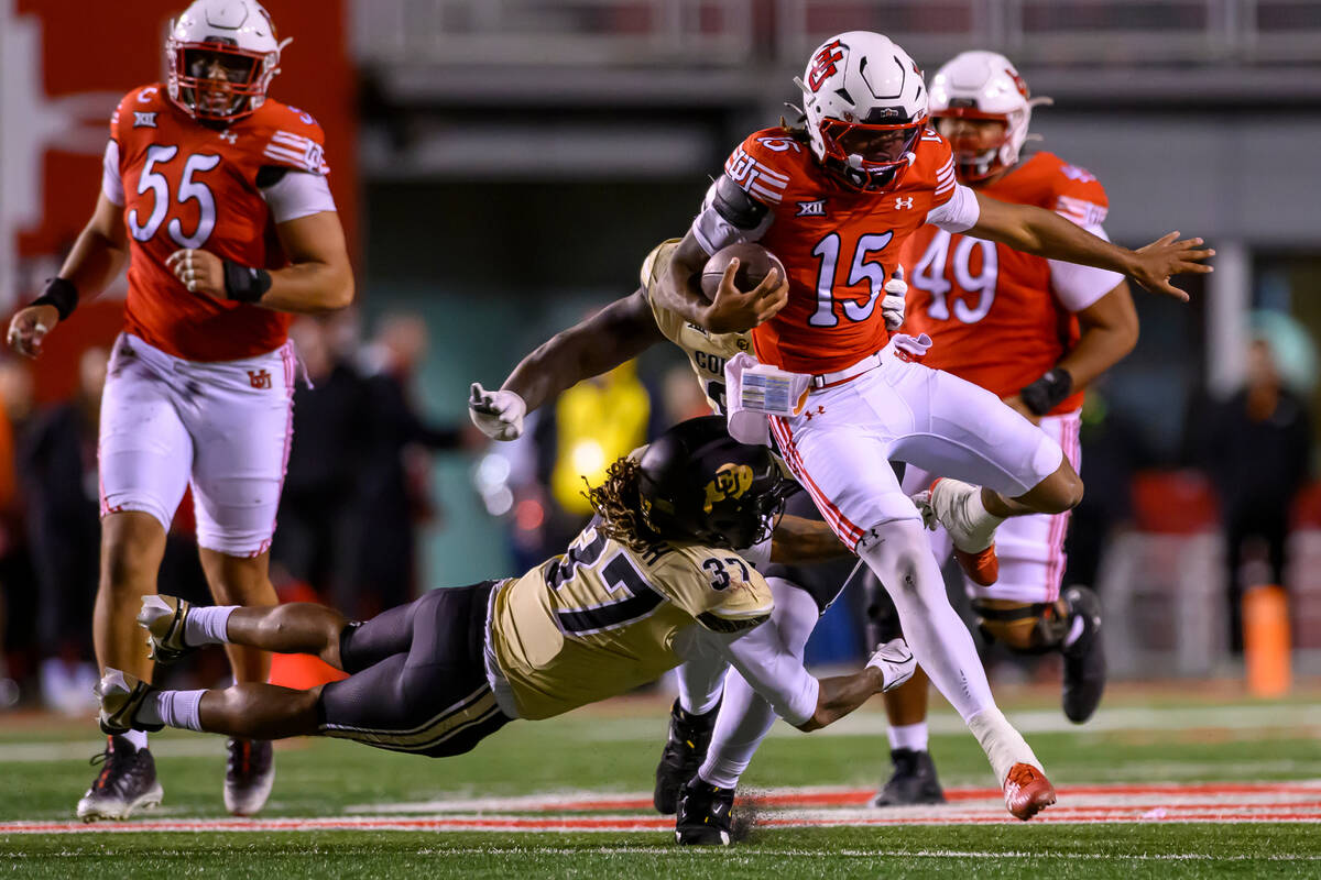 Utah quarterback Byrd Ficklin (15) jumps to avoid the diving tackle from Colorado linebacker Ma ...