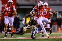 Utah quarterback Byrd Ficklin (15) jumps to avoid the diving tackle from Colorado linebacker Ma ...