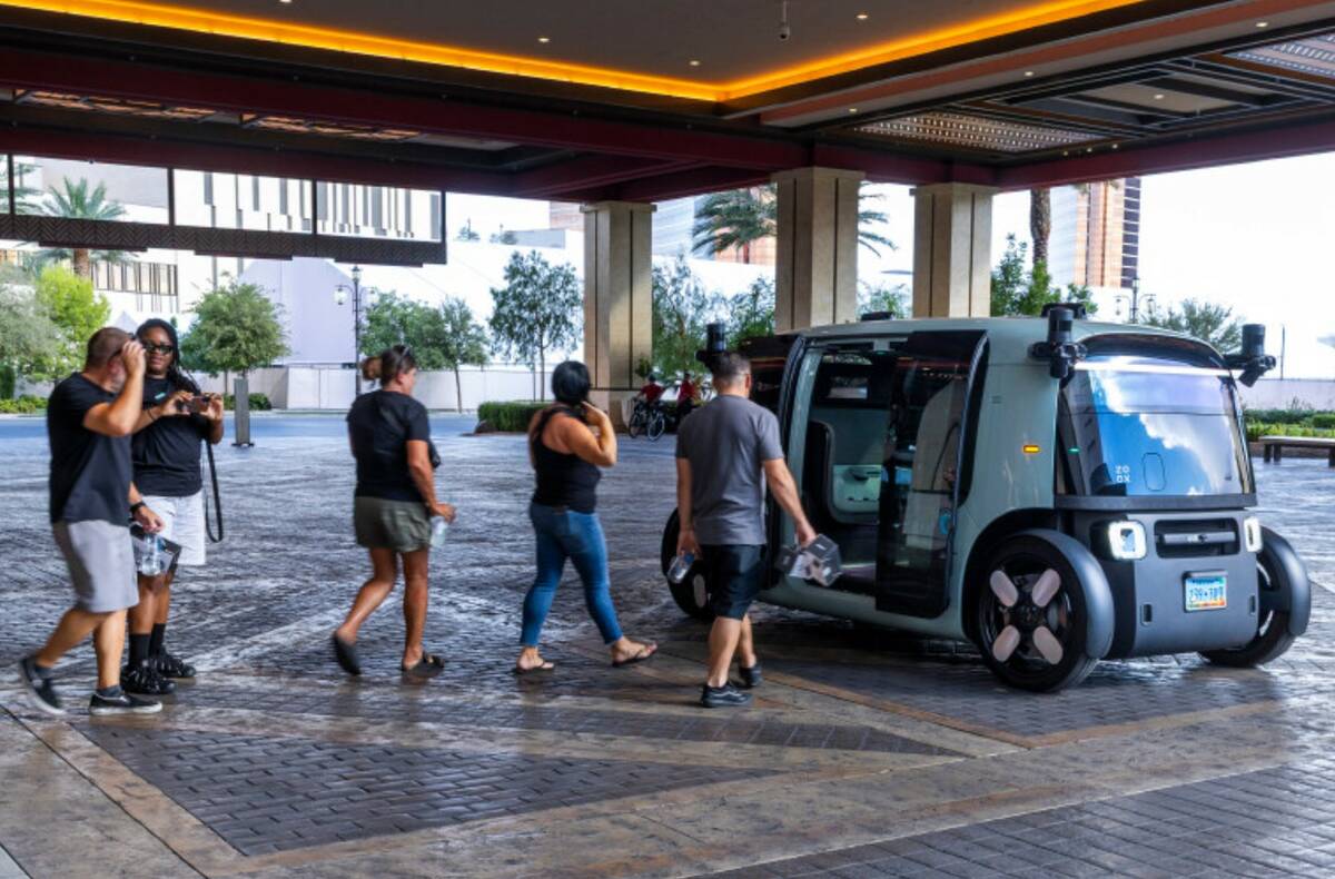 Passengers walk to their Zoox vehicle leaving from Resorts World on Friday, Sept. 5, 2025, in L ...