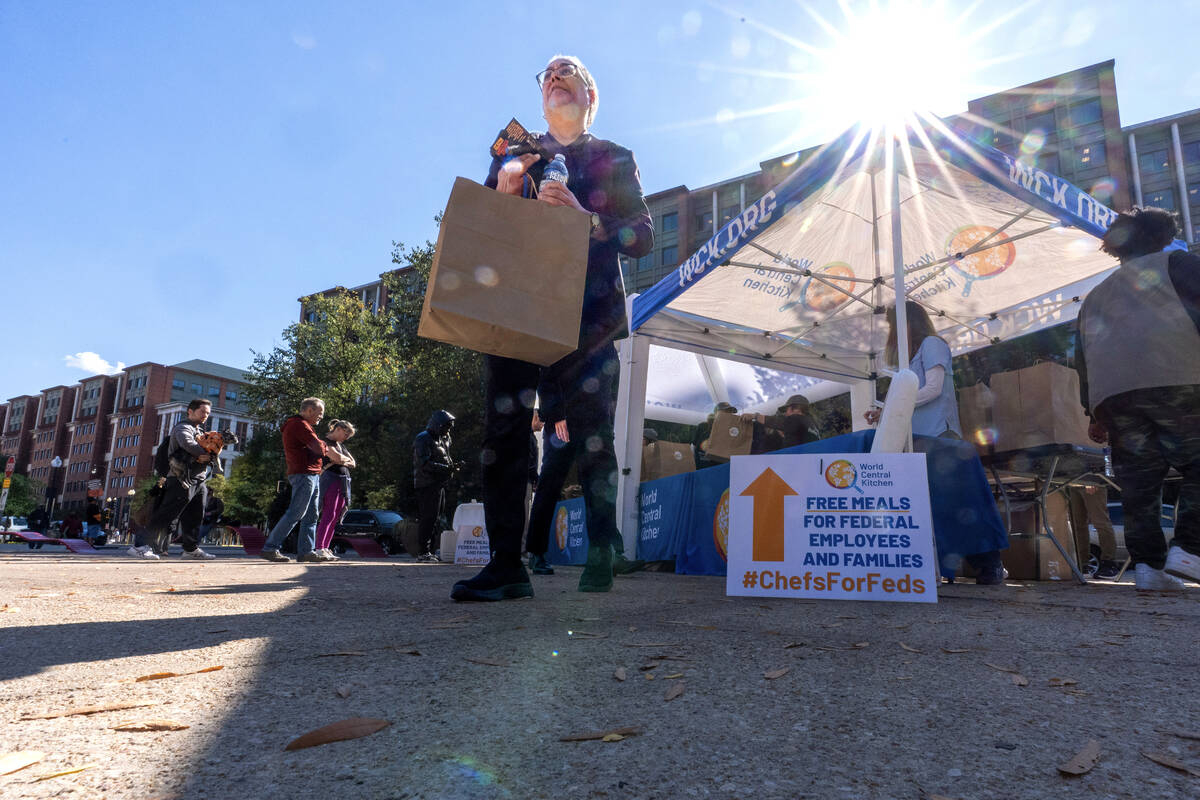 A person walks with a meal from chef Jose Andres' World Central Kitchen as they distribute ...