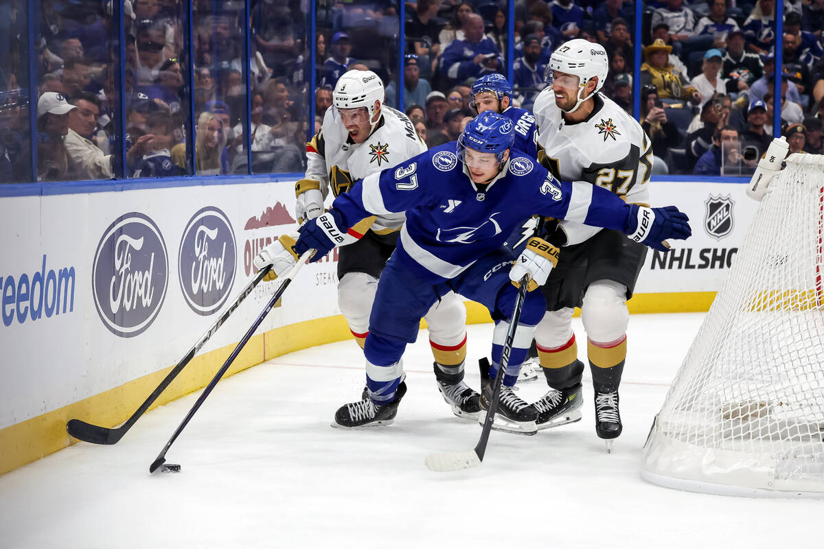 Tampa Bay Lightning's Yanni Gourde (37) tries to split the defense of Vegas Golden Knights ...