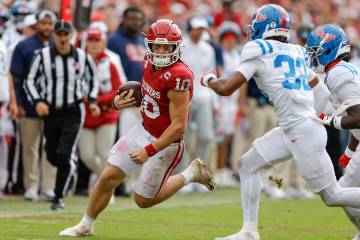 Oklahoma quarterback John Mateer (10) runs for a first down beside Mississippi cornerback Chris ...