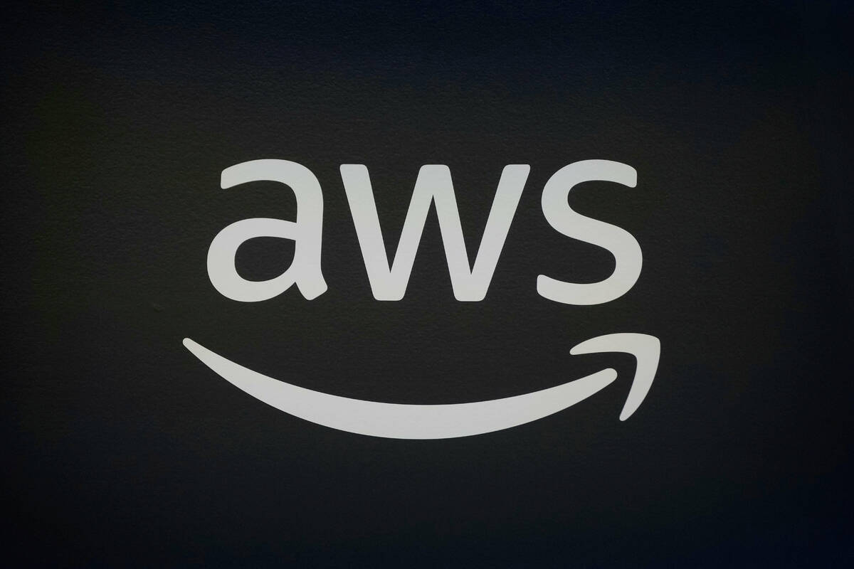 FILE - An AWS, Amazon Web Services, logo is displayed at LlamaCon 2025, an AI developer confere ...