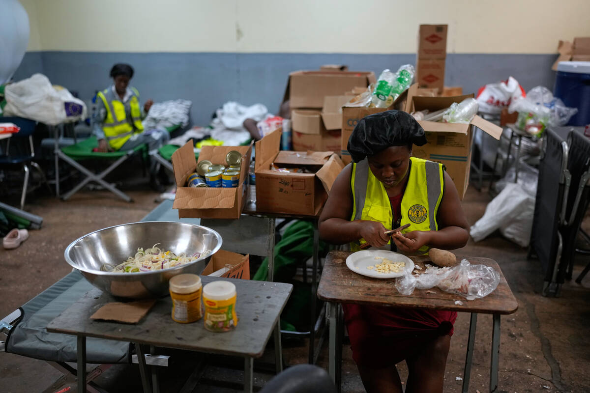 Cooks prepare meals at a shelter set up in a school ahead of Hurricane Melissa's forecast ...