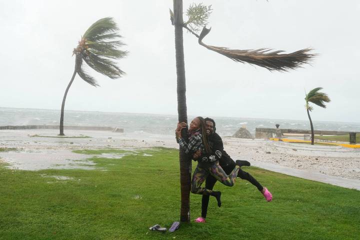A couple jokes around on the coast in Kingston, Jamaica, as Hurricane Melissa approaches, Tuesd ...