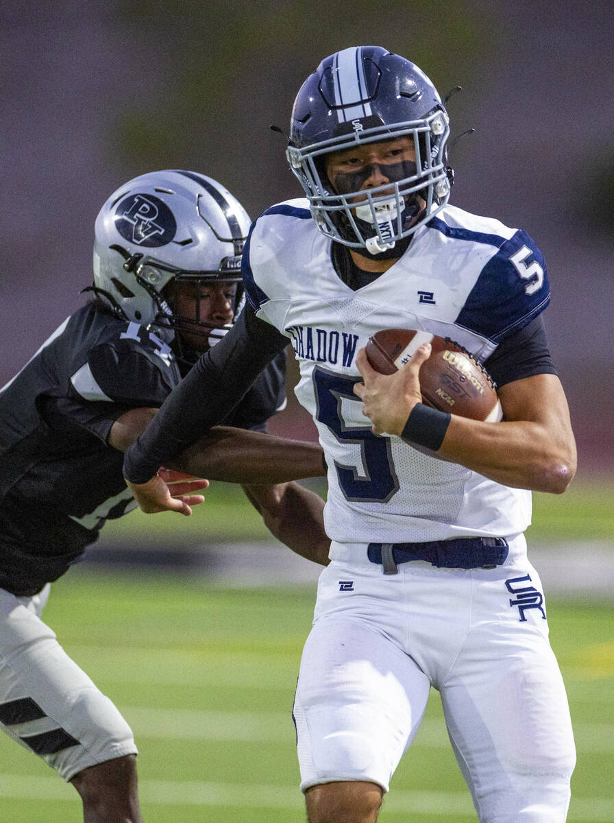 Shadow Ridge quarterback Isaiah Ruiz (5) gets past Palo Verde's X'Zavier McZeal (14) ...
