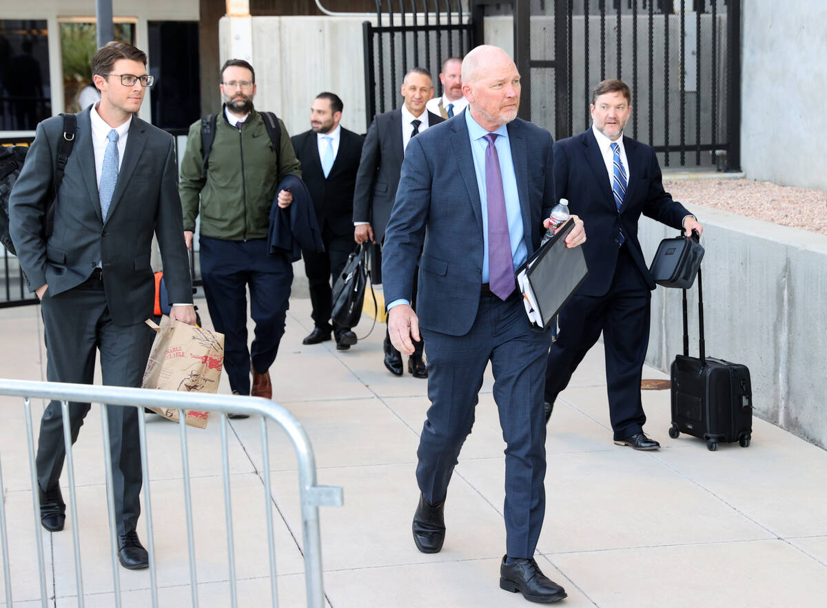 Metropolitan Police Department officer Andrew Locher, front, walks out a back exit at Lloyd Geo ...