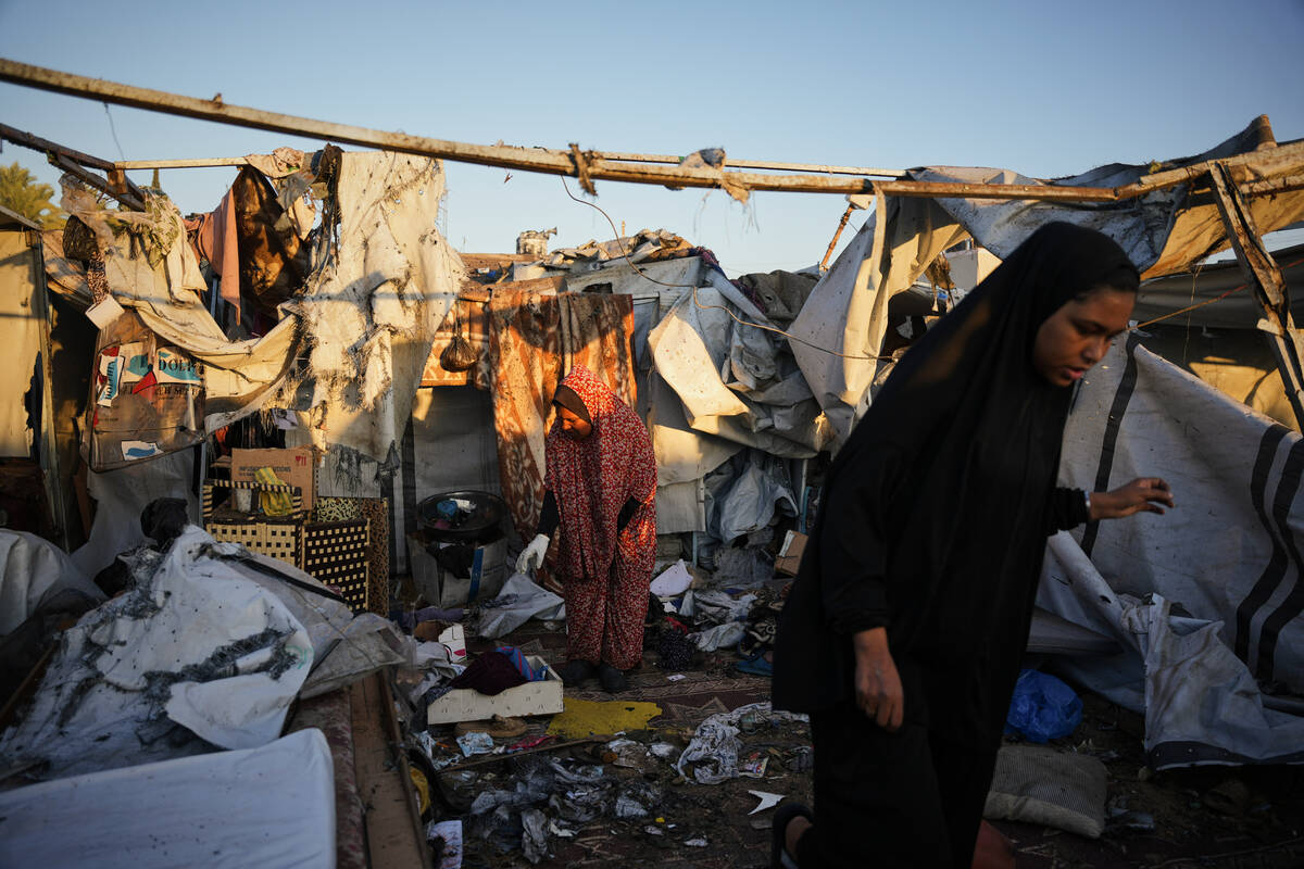 Displaced Palestinians inspect the damage after an Israeli army strike on their tent camp in De ...