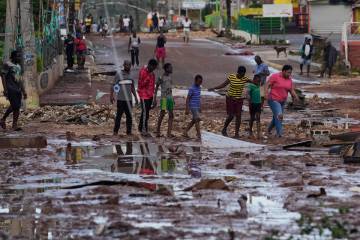 People walk through Santa Cruz, Jamaica, Wednesday, Oct. 29, 2025, after Hurricane Melissa pass ...