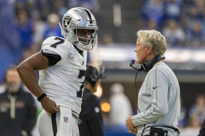 Raiders head coach Pete Carroll meets with Raiders quarterback Geno Smith (7) during a timeout ...