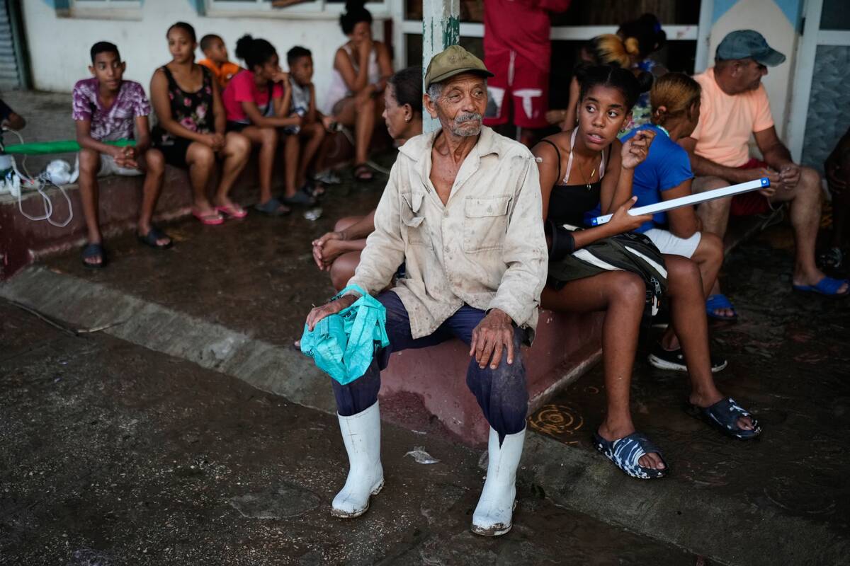 People wait to charge electrical appliances in El Cobre, Cuba, Wednesday, Oct. 29, 2025, in the ...