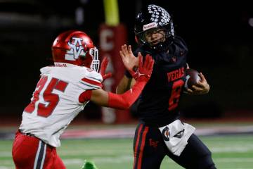 Las Vegas High's quarterback Tanner Vibabul (8) avoids a tackle from Arbo View's defe ...