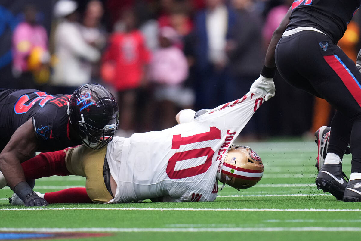 San Francisco 49ers quarterback Mac Jones (10) is sacked by Houston Texans defensive end Will A ...