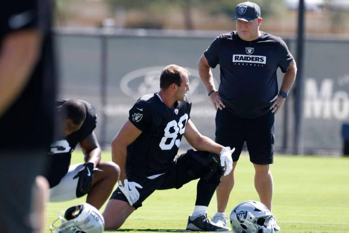 Raiders offensive coordinator Chip Kelly interacts with tight end Brock Bowers (89) during team ...
