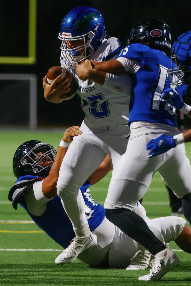 Desert Pines defensive players try to take down Green Valley quarterback Michael Lewis (15) dur ...