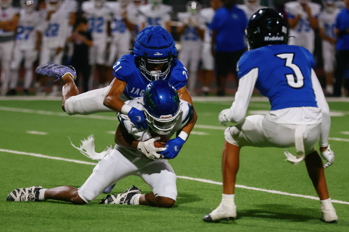 Desert Pines safety Jalen Alvarez (21) tackles Green Valley wide receiver Ty Williams (18) duri ...
