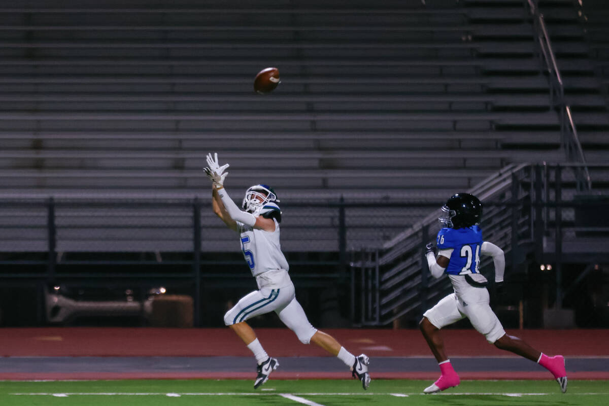 Green Valley wide receiver Sam Byington (5) reaches for a pass as Desert Pines defensive back D ...
