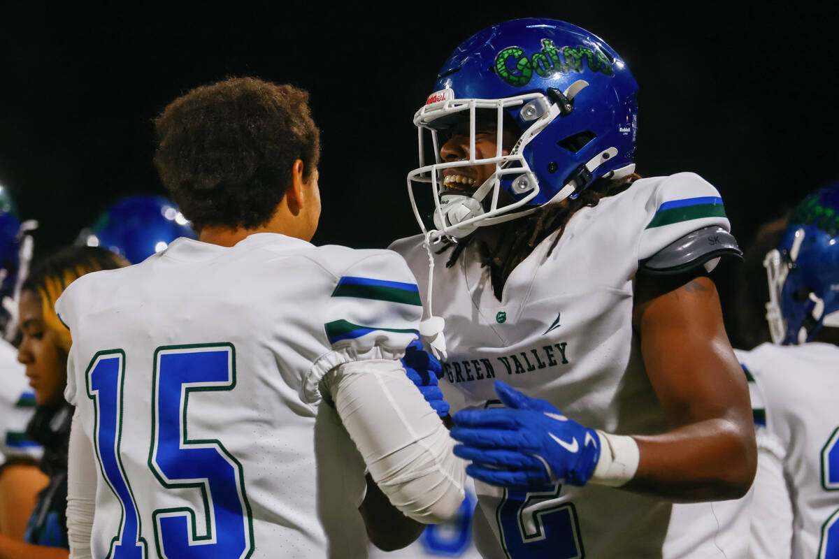 Green Valley quarterback Michael Lewis (15) and Green Valley wide receiver/outside linebacker E ...