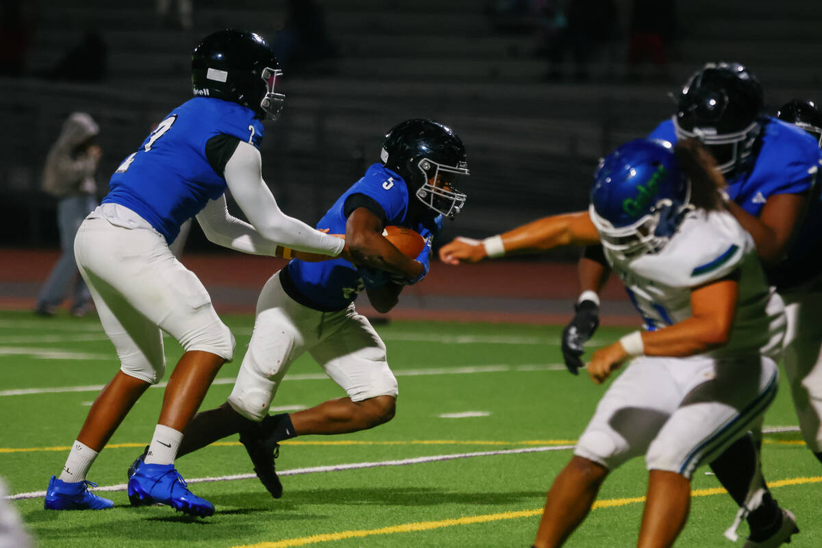 Desert Pines quarterback Jerome Sequeira (2) hands the ball off to Desert Pines running back Ma ...