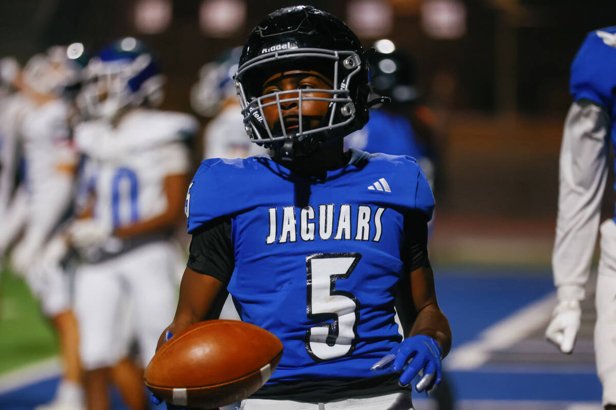 Desert Pines running back Marcus Williams (5) hands the ball back to the referee after running ...