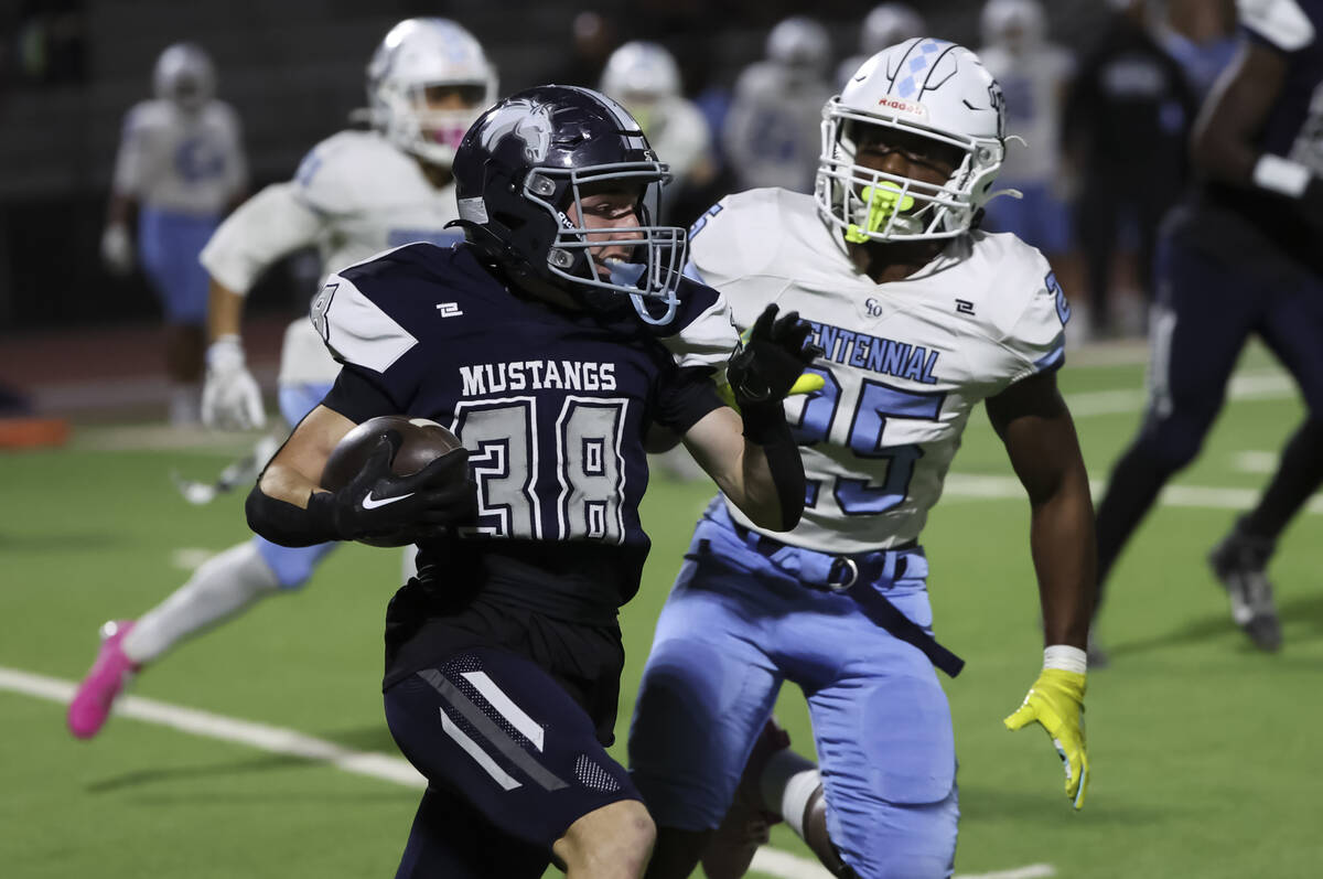 Shadow Ridge running back/free safety Hawkin Ledingham (38) runs the ball under pressure from C ...